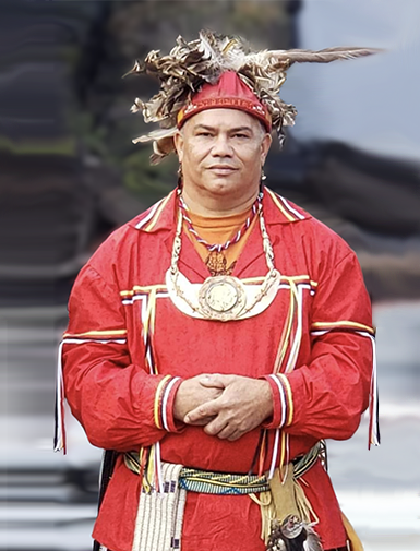 Photo of Chief Mann in traditiional attire with beadwork and feathered headwear 